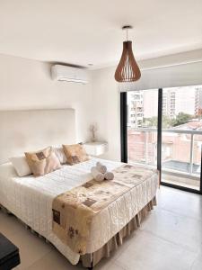 een slaapkamer met een groot bed met een groot raam bij Alcazar Buona Vista Suites in Salta