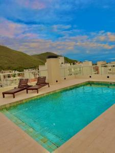 een zwembad met 2 stoelen en een gebouw bij Alcazar Buona Vista Suites in Salta