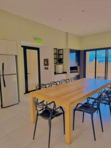 een grote houten tafel en stoelen in een keuken bij Alcazar Buona Vista Suites in Salta +21 foto's