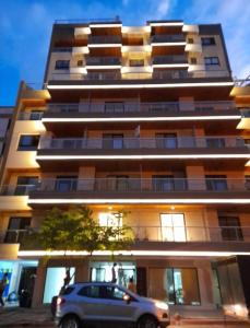 een auto geparkeerd voor een hoog gebouw bij Alcazar Buona Vista Suites in Salta