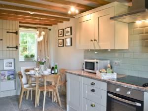 eine Küche mit Tisch und Arbeitsplatte in der Unterkunft Ivy Bush Cottage in Llanddewi-Brefi