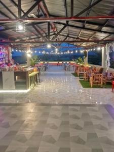 Habitación grande con mesas, sillas y luces. en American Roadhouse Hotel and Restaurant, en Candijay