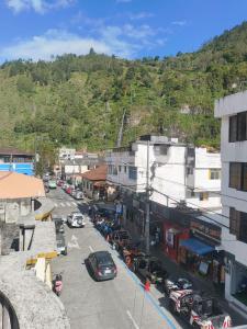 a city street with cars parked in a parking lot at Posada Los Olivos in Baños