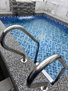 a swimming pool with a metal faucet at Mi Haven Homestay Seribong KB City in Kota Bharu