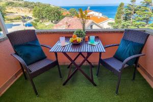 a table and two chairs with a bowl of fruit on a balcony at Apartments in Stara Baska - Island Krk 34416 in Stara Baška +3 photos