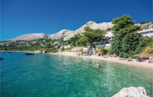 a group of people swimming in the water on a beach at Apartments in Stara Baska - Island Krk 34416 in Stara Baška