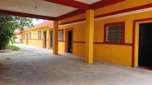 ein leerstehendes Gebäude mit gelben und roten Wänden in der Unterkunft Hotel Casa Zued chichen itza in Pisté + 6 Fotos