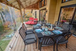 a dining table and chairs on a deck at Le SUMMUM in Sainte Anne des Lacs