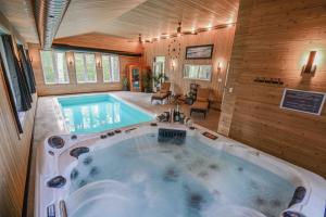 a large bath tub in a room with a swimming pool at Le SUMMUM in Sainte Anne des Lacs