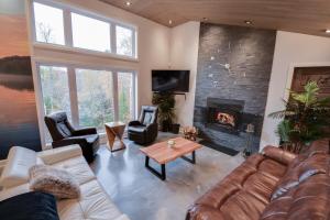 a living room with a couch and a fireplace at Le SUMMUM in Sainte Anne des Lacs