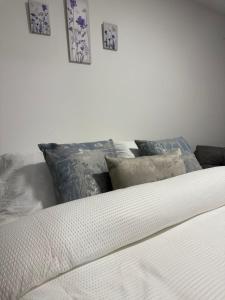 a white bed with pillows and pictures on the wall at Apartamento Limón Azul in Sogamoso