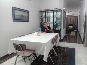 a man sitting at a table in a room at Maya Eco Guest House in Dhaka +33 photos