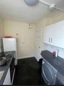 a kitchen with a white refrigerator and a black counter top at Flat 9 Haden in Wolverhampton +16 photos