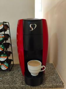 a coffee maker with a cup of coffee on a counter at Apartamento in Viçosa