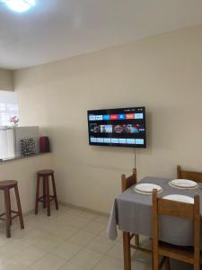 a dining room with a table and a tv on the wall at Apartamento in Viçosa
