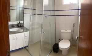 a bathroom with a toilet and a glass shower at 800m da UFV, 500m da rodoviária, Wi-Fi, TV smart. in Viçosa