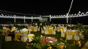 um grupo de tabelas com opções de tabelas amarelas e brancas em Hotel Manas Plus em Khandwa