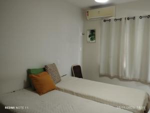 a small room with two beds and a window at Refúgio aconchegante in Salvador +32 photos