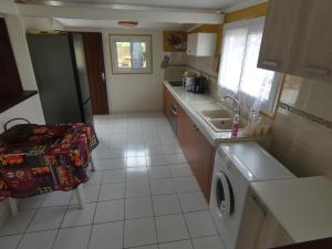 een keuken met een spoelbak en een wasmachine bij Gîte 2ch proche plages, Jardin privé, Port-Louis in Port-Louis