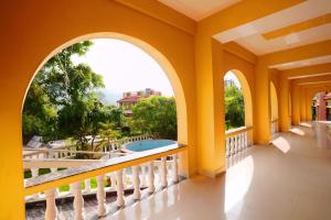 an arched balcony with a view of a pool at MVT Guesthouse & Restaurant (Rishikesh) in Rishīkesh