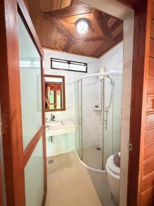 a bathroom with a shower and a toilet and a sink at Areeya phubeach resort wooden house Coliving Coworking in Ban Chong Phli