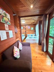 a living room with a couch and a bed at Areeya phubeach resort wooden house Coliving Coworking in Ban Chong Phli