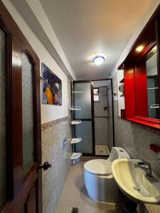 a bathroom with a sink and a toilet and a red cabinet at Altura View Stay in La Paz