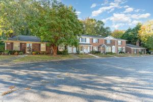 a house with a tree in front of a street at Haven House-10 Min From PTI in Greensboro