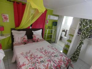 een slaapkamer met een bed met roze en groene muren bij Gîte 2ch proche plages, Jardin privé, Port-Louis in Port-Louis