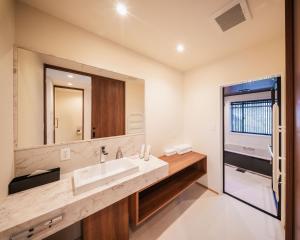 a bathroom with a sink and a large mirror at Kamuy Chalet Hakuba by Jade Group in Hakuba +20 photos
