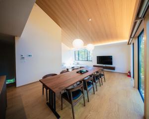 a dining room with a large wooden table and chairs at Kamuy Chalet Hakuba by Jade Group in Hakuba