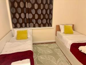 ウォルヴァーハンプトンにあるFlat 8 Hadenのベッドが2つと窓がある小さな部屋