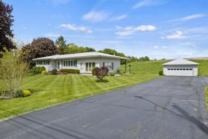 una casa blanca en una colina con entrada para autos en Charming Farmhouse Retreat - King Suite, 