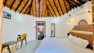 a bedroom with a bed and a table and a desk at Holiday Homestay dholavira 