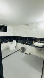 a white bathroom with two sinks and a mirror at Holiday Homestay dholavira 