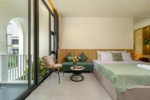 a bedroom with a bed and a couch and a balcony at BQ Manor by Class6 in Danang +49 photos