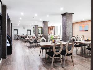 a dining room with tables and chairs in a restaurant at Jomtien Sands Residence in Jomtien Beach