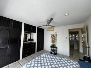 eine Küche mit schwarzen Schränken und einem Deckenventilator in der Unterkunft Las Fuentes in Mérida