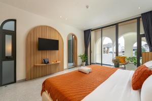 a bedroom with a large bed with a flat screen tv at BQ Manor by Class6 in Danang