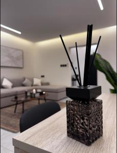 un soggiorno con un divano e un tavolo con una pianta di استديو لوفينا 2 a Riyad