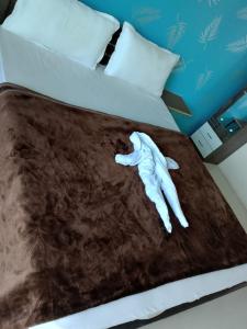 a bed with a white hand laying on it at hotel shreejee in Himatnagar
