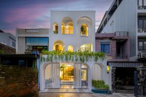 a white house with a gate and plants at BQ Manor by Class6 in Danang