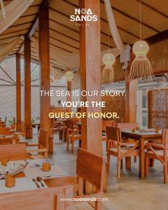a restaurant with wooden tables and chairs and a sign at Noa Sands By Ceylon Vistas in Talpe