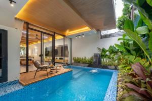 an indoor pool with a table and a chair next to a house at BQ Manor by Class6 in Danang