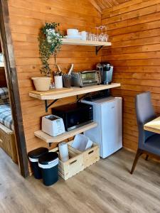 a kitchen with wooden walls with shelves and a microwave at chalet 4 - Domaine de l'Archipel in Sorel