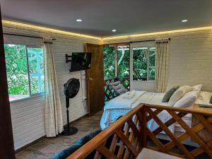 a bedroom with a bed and a balcony with a television at Cabañas betania in Santa Marta
