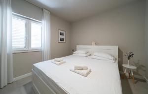 a white bedroom with a large white bed with towels on it at Nice Apartment In Selca With Kitchen in Selca