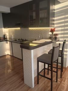 a kitchen with a counter with chairs and a sink at Las Palmas Apart in Tacna