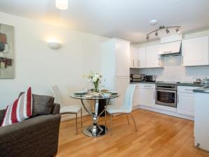 eine Küche und ein Wohnzimmer mit einem Tisch und einer Couch in der Unterkunft 8 Belvedere Court in Paignton