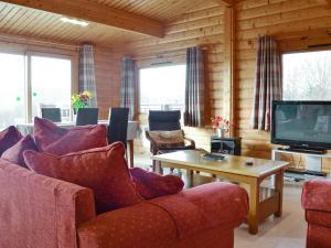 a living room with couches and a tv and a table at Cider Mill Lodge - Hw7420 in Tintern